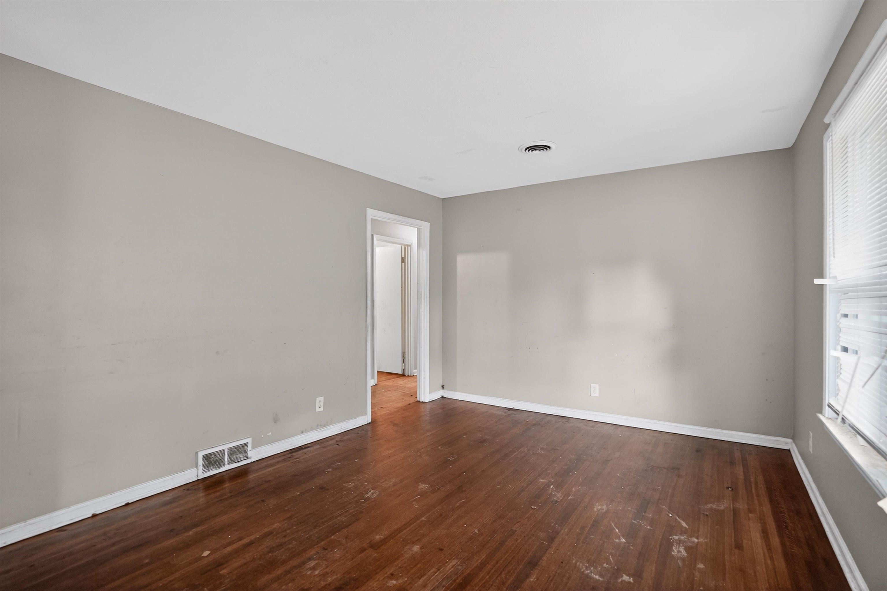 1890 Pennel Road Memphis, TN 38116 - Photo 16 of 25 Interior space featuring wood-finish flooring, light gray walls, white trim, and a window with blinds