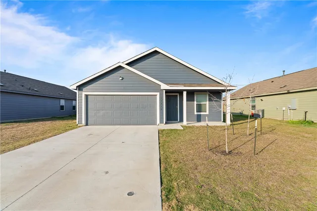 a view of a house with a yard and garage
