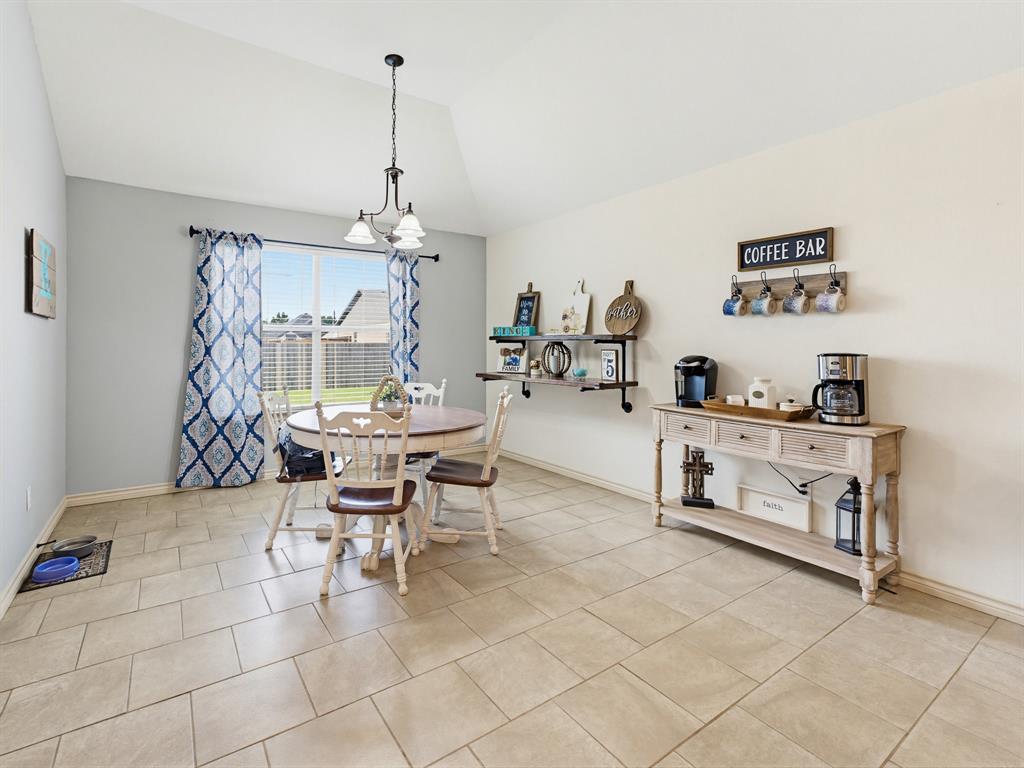 2108 Ridgewood Drive Bridgeport, TX 76426 - Photo 17 of 35 Vaulted ceiling dining area featuring light tile flooring, a clear paneled door, and a bright window overlooking the exterior