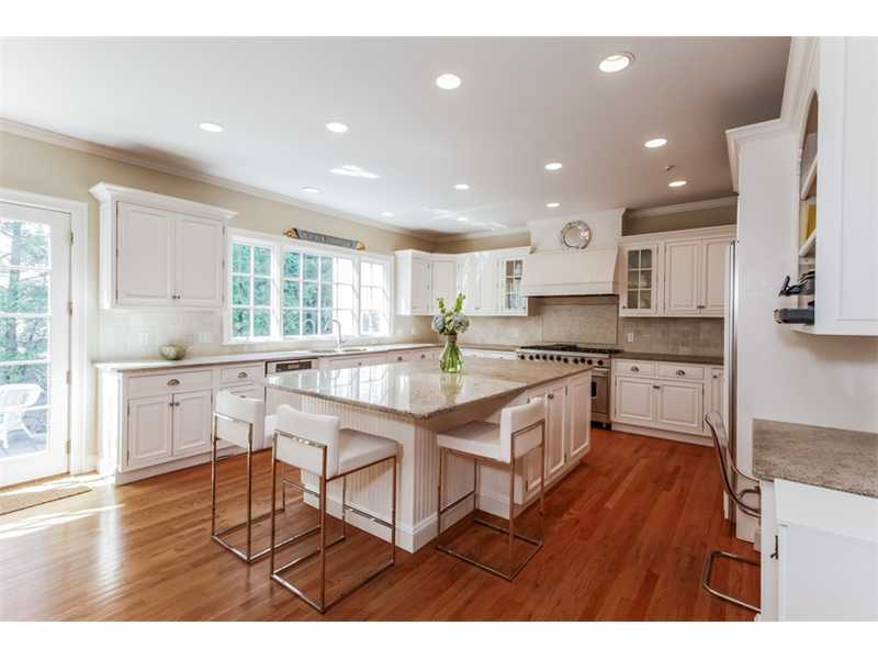 141 Brookside Road Darien, CT 06820 - Photo 8 of 26 a kitchen with stainless steel appliances granite countertop wooden cabinets a sink a stove a dining table and chairs