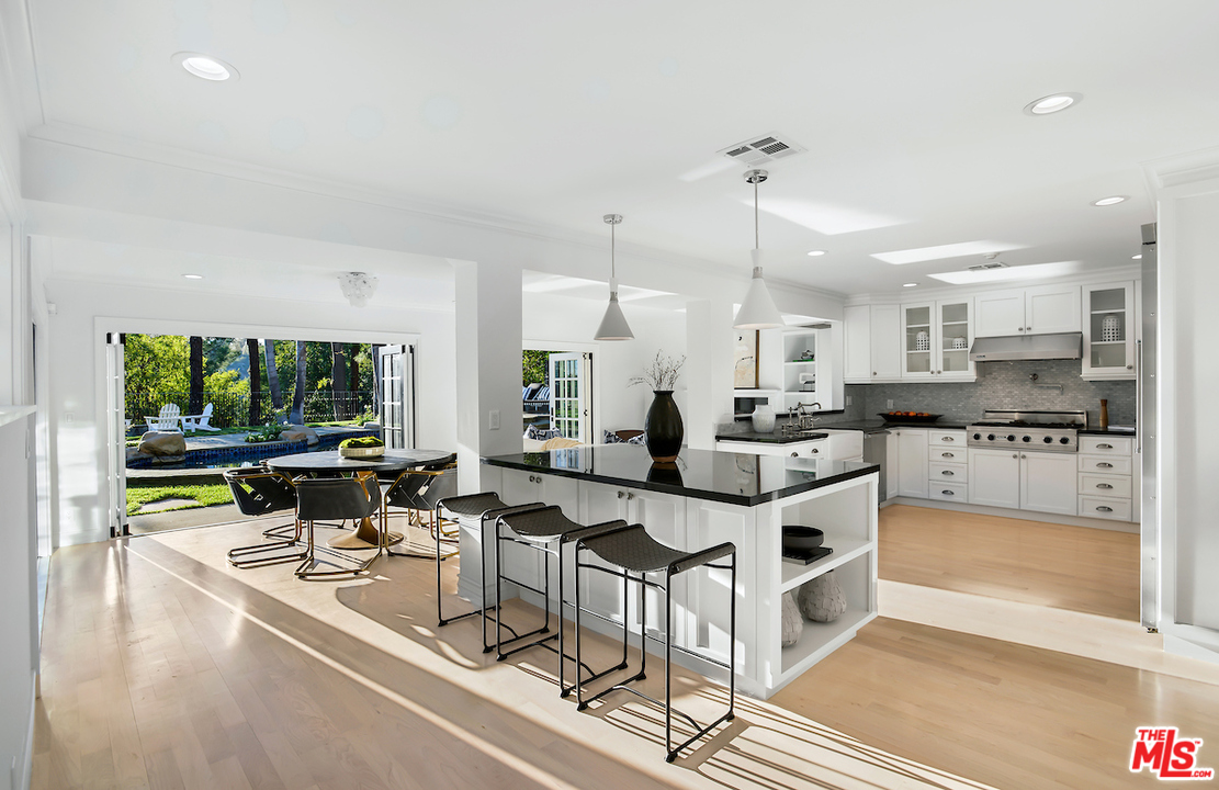 9653 Wendover Drive Beverly Hills, CA 90210 - Photo 17 of 34 a kitchen with stainless steel appliances kitchen island a large counter top space a sink a window and cabinets