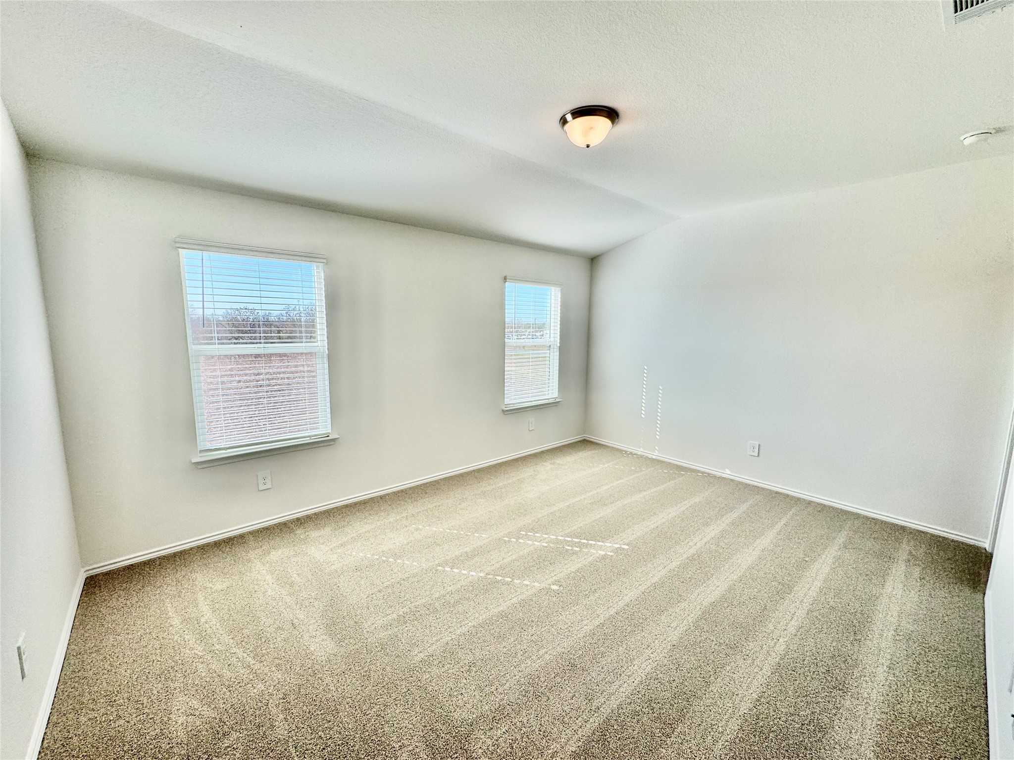 104 Calcite Road, Unit 4 Kyle, TX 78640 - Photo 4 of 7 Carpeted empty room with a textured ceiling and vaulted ceiling