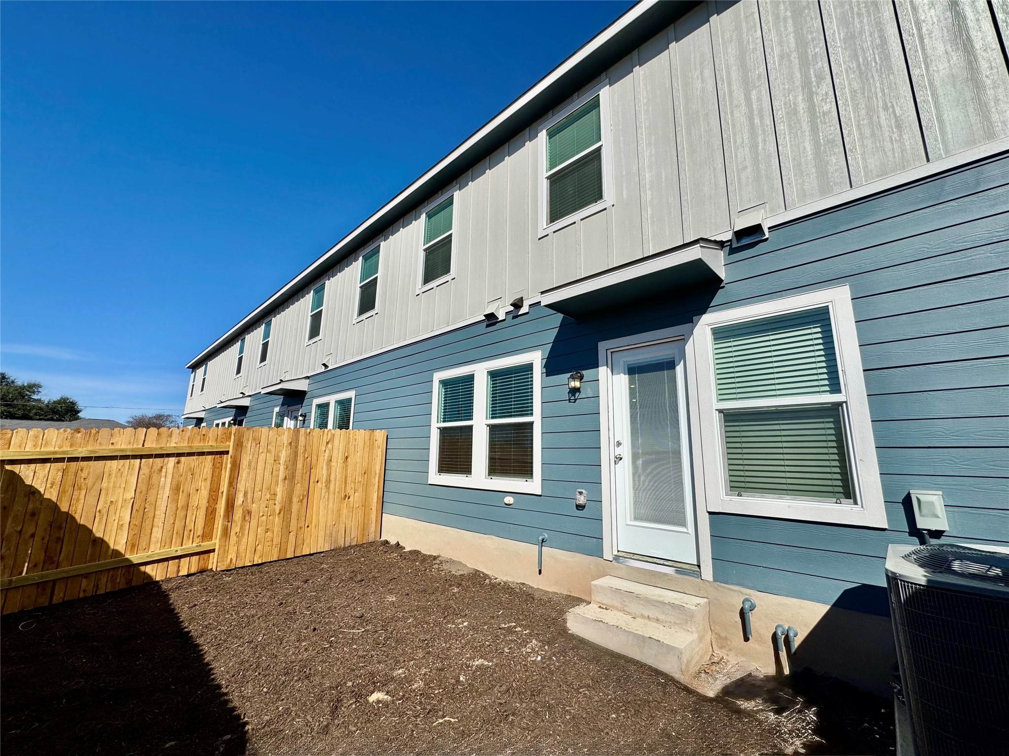 104 Calcite Road, Unit 4 Kyle, TX 78640 - Photo 5 of 7 Rear view of house featuring entry steps