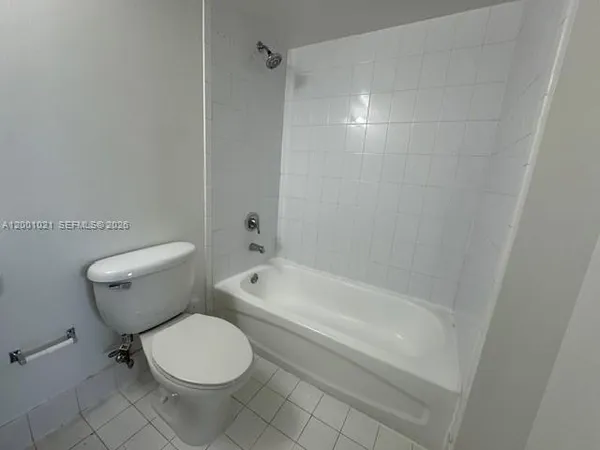 a white toilet sitting next to a bath tub