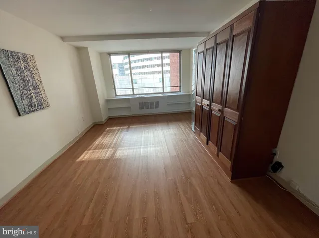 a view of empty room with wooden floor and staircase