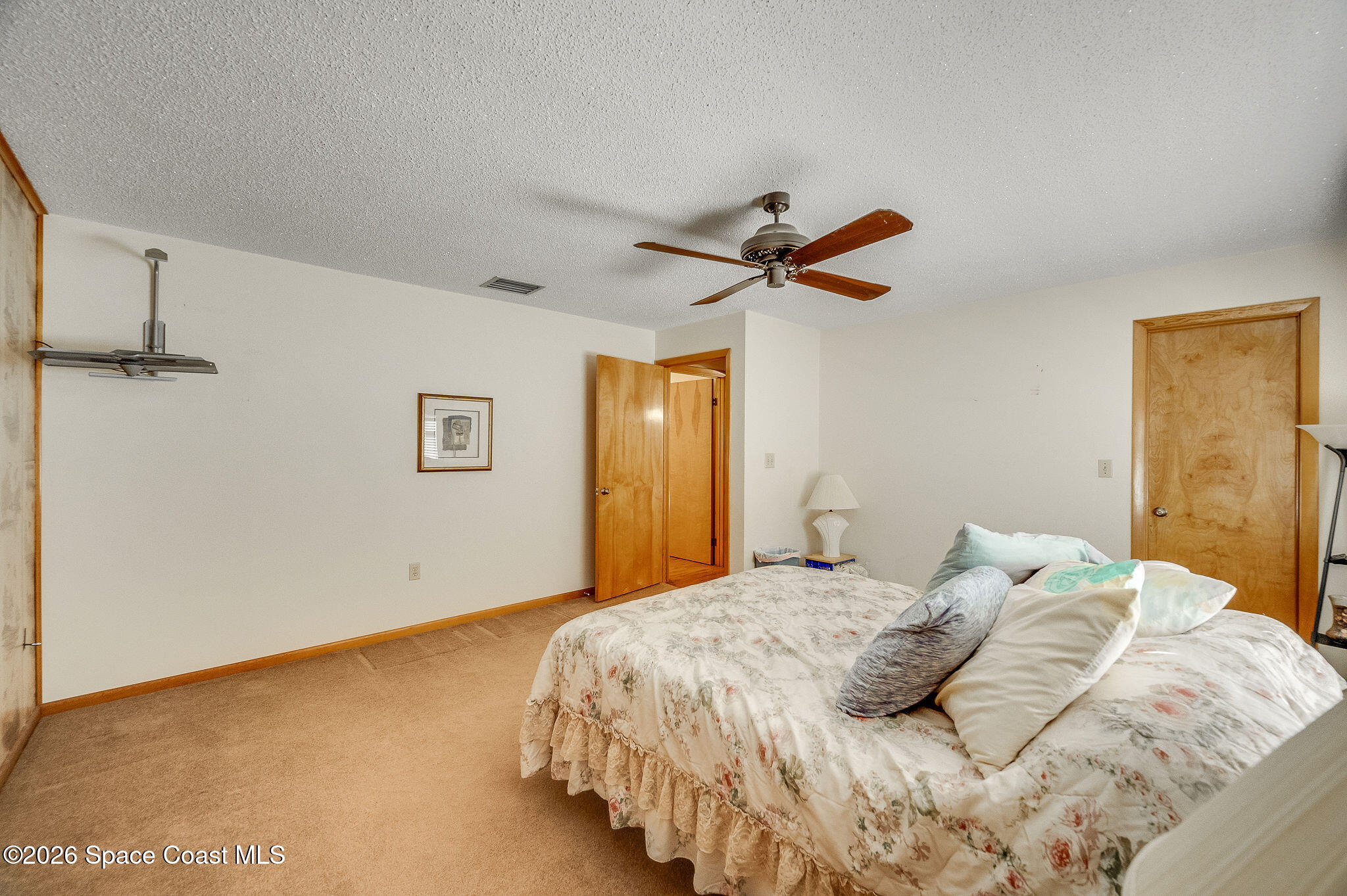 4600 Janet Road Cocoa, FL 32926 - Photo 21 of 50 a bedroom with a large bed and a chandelier