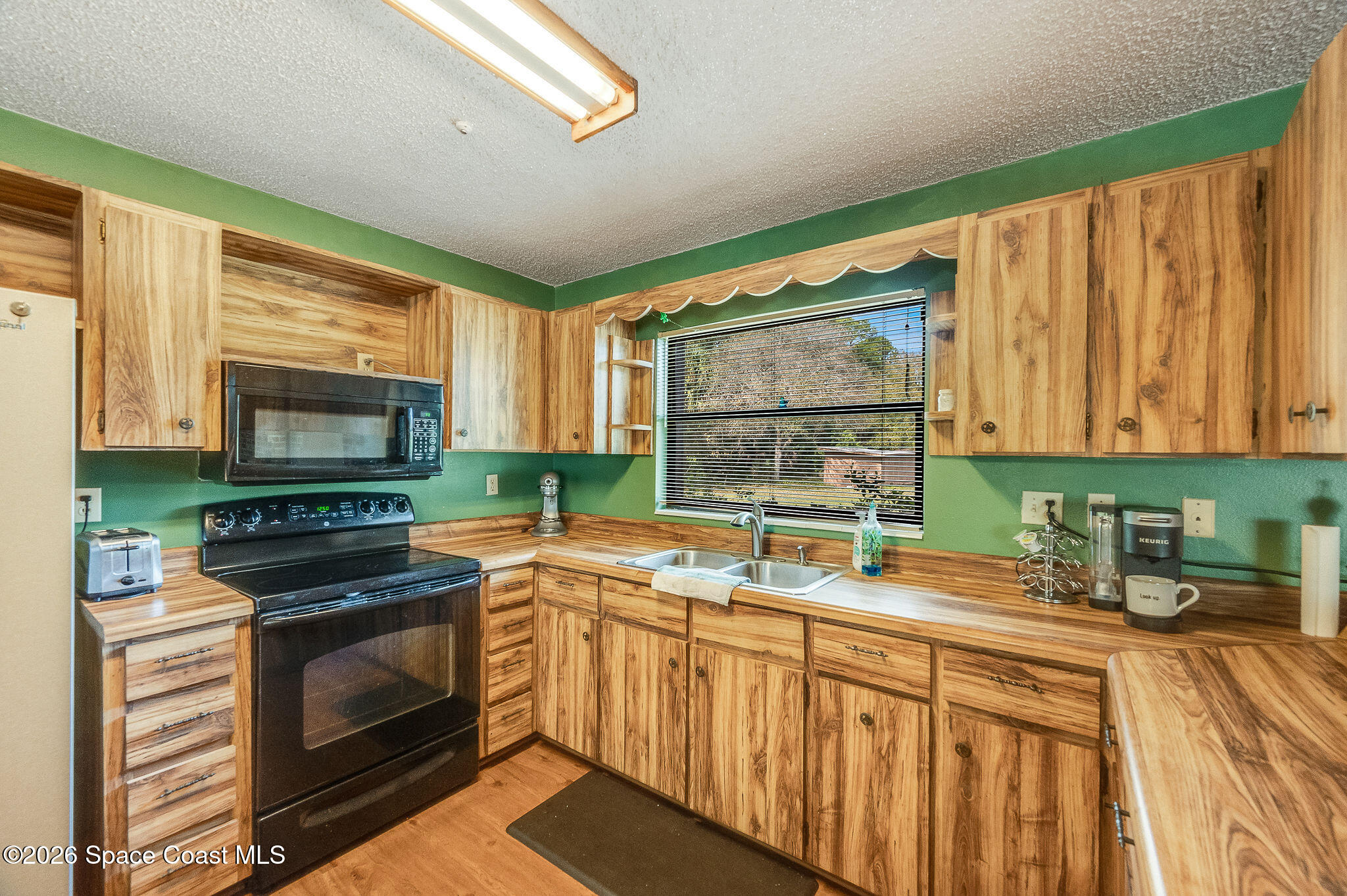 4600 Janet Road Cocoa, FL 32926 - Photo 10 of 50 a kitchen with stainless steel appliances a stove sink microwave and cabinets