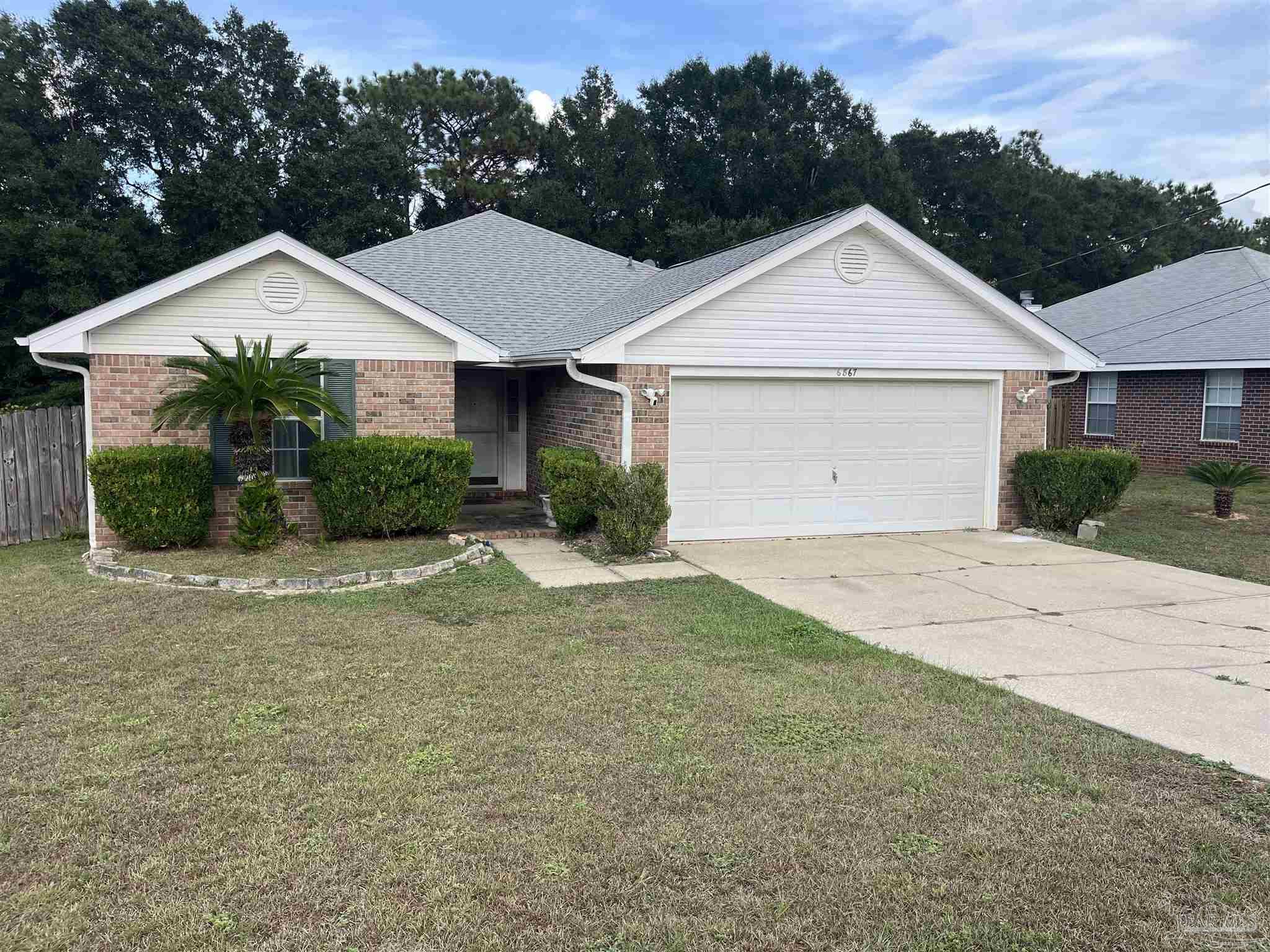 6867 Cedar Ridge Circle Milton, FL 32570 - Photo 1 of 13 a front view of a house with a yard and garage