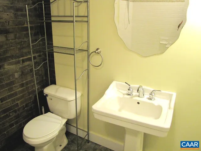 a bathroom with a sink mirror and toilet