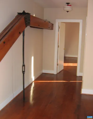 a view of a small space with wooden floor and a ceiling fan