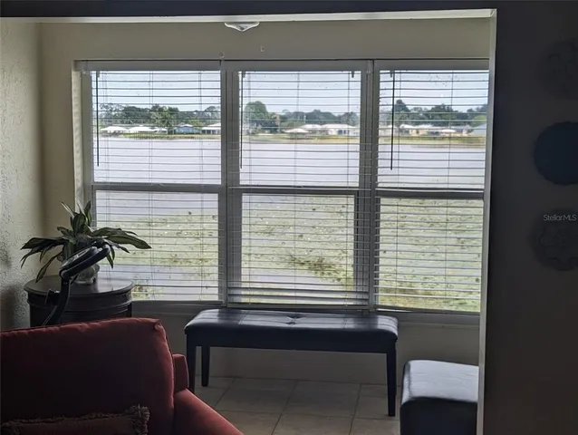 a view of a room with a large window and furniture