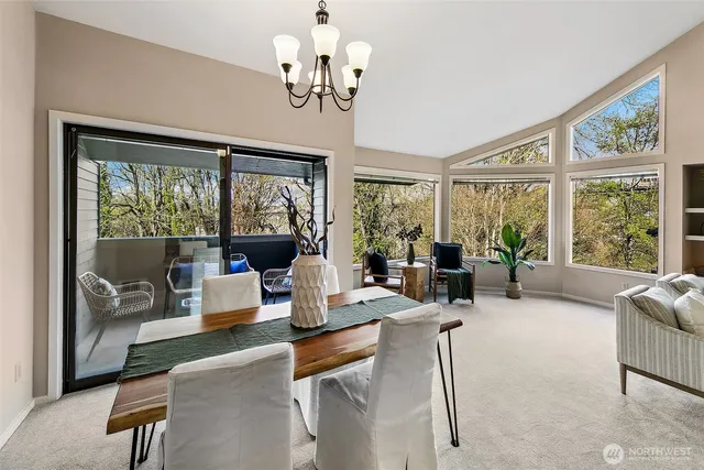 a living room with furniture large windows and wooden floor