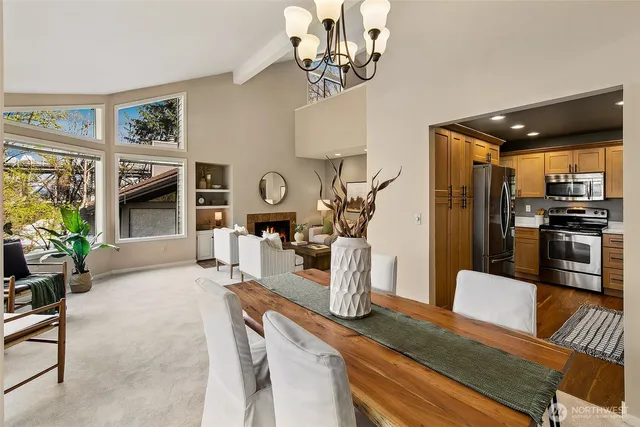 a view of a dining room with furniture a kitchen and chandelier