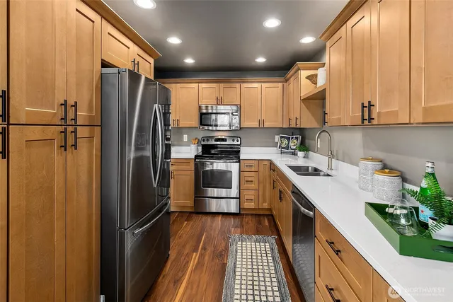 a kitchen with stainless steel appliances a refrigerator sink and white cabinets