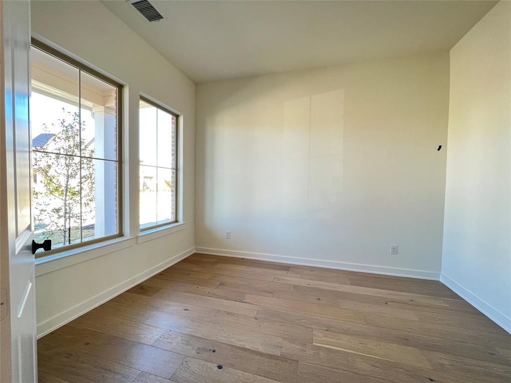 15625 Hawks Pass Road Frisco, TX 75035 - Photo 6 of 27 an empty room with wooden floor and windows