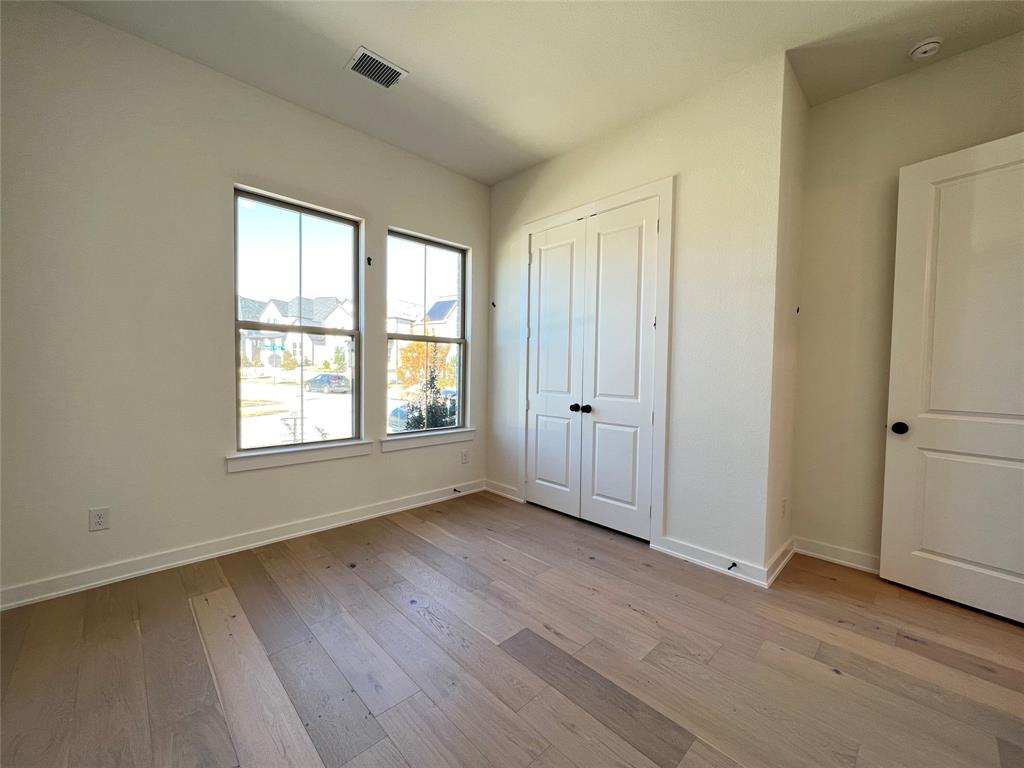 15625 Hawks Pass Road Frisco, TX 75035 - Photo 7 of 27 an empty room with wooden floor and windows