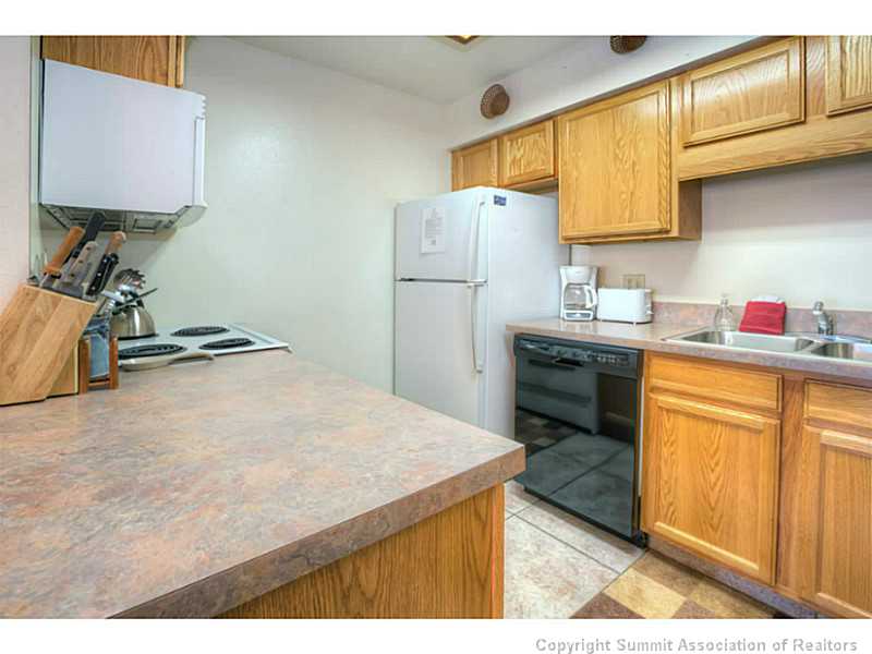 875 4 O Clock Road, Unit 2 Breckenridge, CO 80424 - Photo 8 of 13 a kitchen with a sink appliances and cabinets