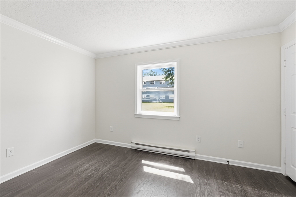 30 Abbey Road, Unit 102 Leominster, MA 01453 - Photo 12 of 15 an empty room with wooden floor and windows