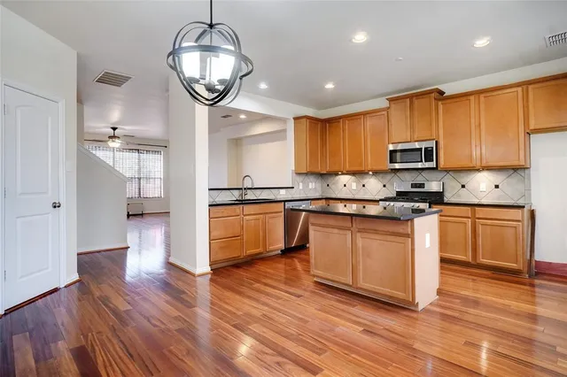 a kitchen with granite countertop a stove a sink and a refrigerator