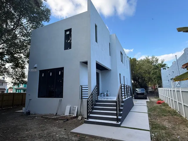 a view of a house with stairs and a yard