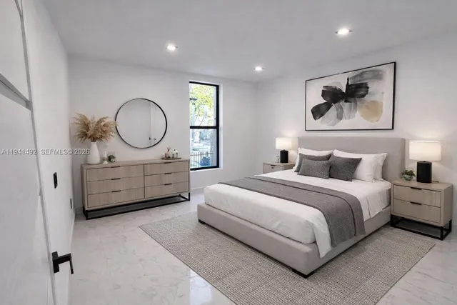 a spacious bedroom with a bed and painting on the wall