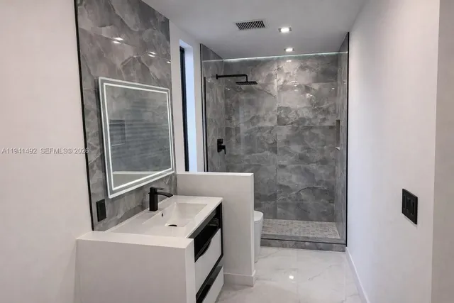 a bathroom with a shower a sink and a mirror