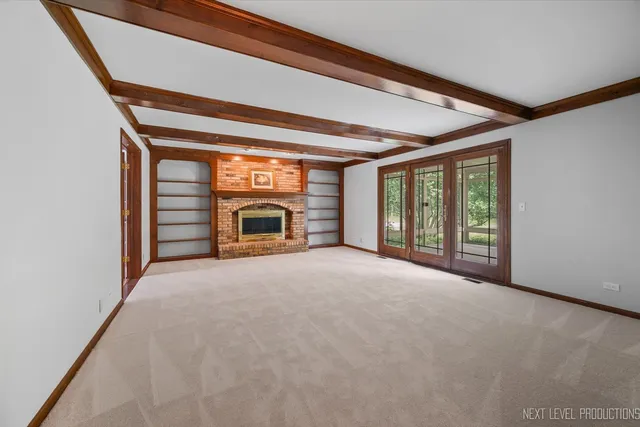 a view of an empty room with a fireplace and a window