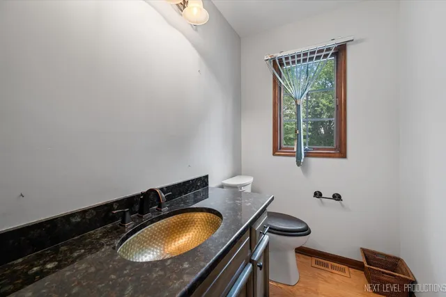 a bathroom with a granite countertop sink toilet and mirror