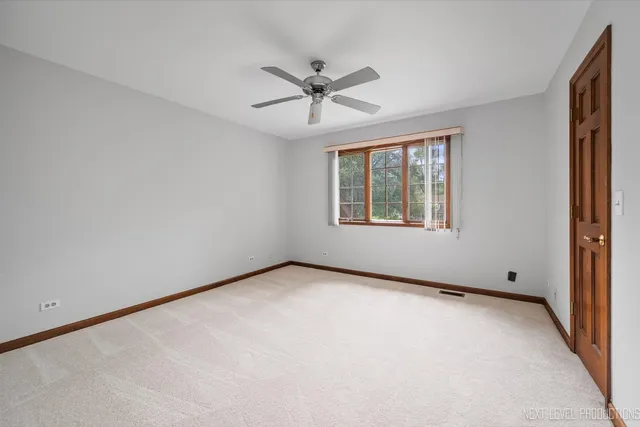 an empty room with windows and ceiling fan