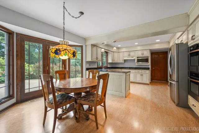 a view of a dining room and livingroom with furniture wooden floor a chandelier