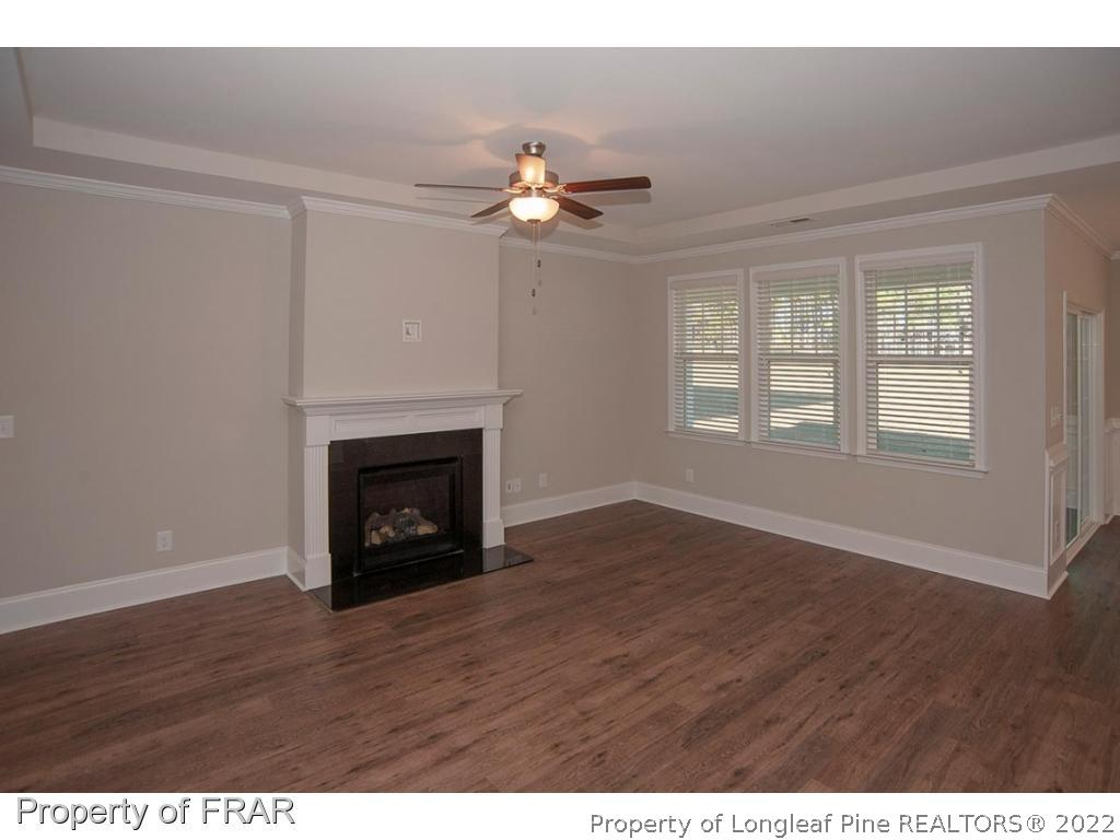 475 Kerr Lake Road Aberdeen, NC 28315 - Photo 16 of 29 a view of an empty room with wooden floor fireplace and a window