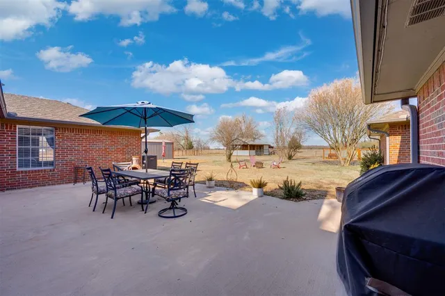 a view of a chairs and table in backyard of the house