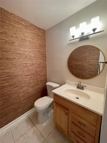 a en suite bathroom with a granite countertop sink and a mirror