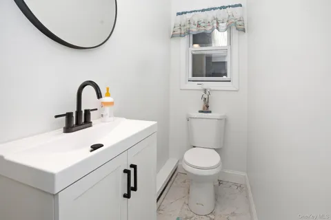 a bathroom with a sink a toilet and mirror