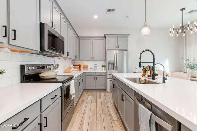 a kitchen with stainless steel appliances white cabinets and a stove top oven