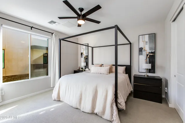 a large bedroom with a large bed and a flat tv screen