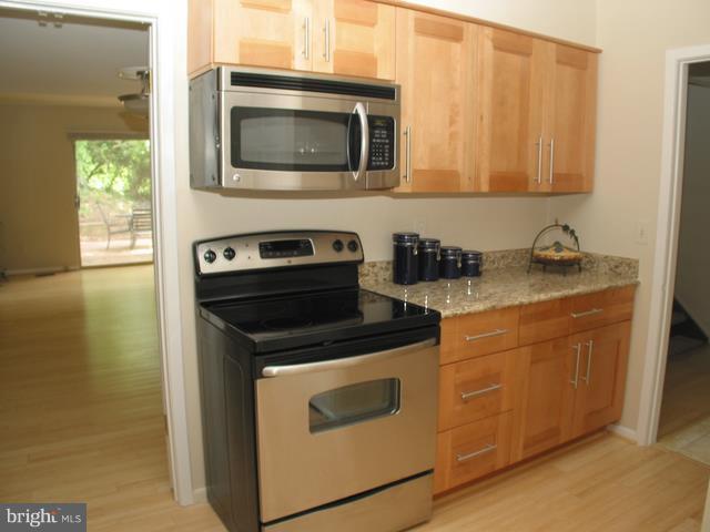 9247 Three Oaks Drive Silver Spring, MD 20901 - Photo 12 of 30 a kitchen with stainless steel appliances granite countertop a stove microwave and cabinets