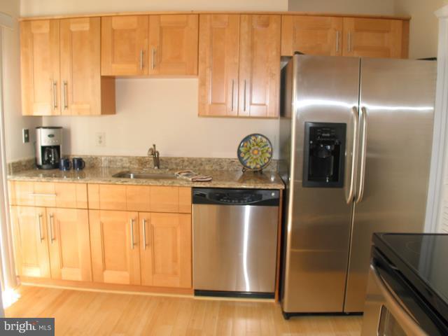 9247 Three Oaks Drive Silver Spring, MD 20901 - Photo 14 of 30 a kitchen with stainless steel appliances granite countertop a refrigerator and a stove