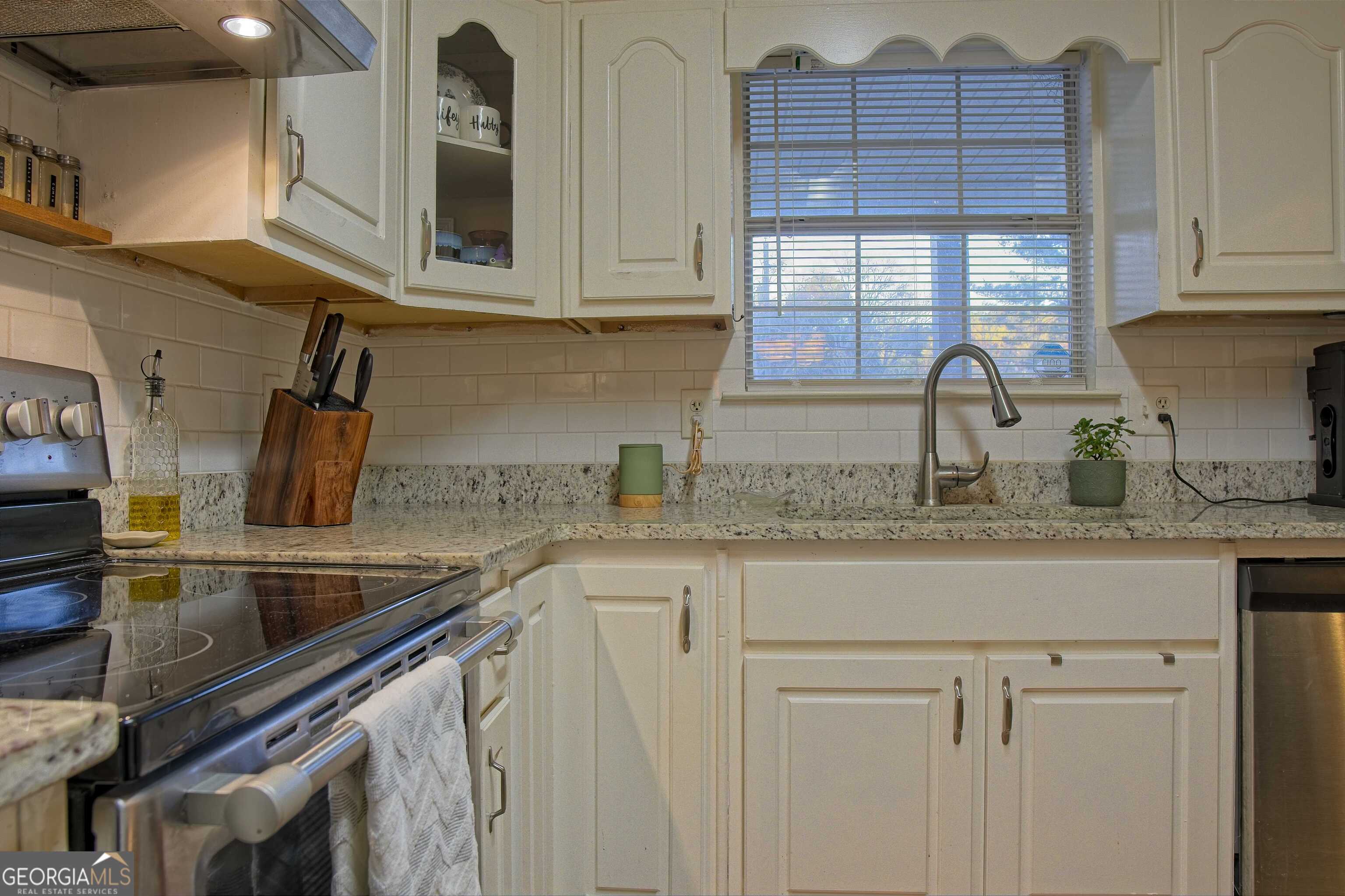 705 Baker Road Oxford, GA 30054 - Photo 15 of 50 a kitchen with granite countertop stainless steel appliances a sink and cabinets