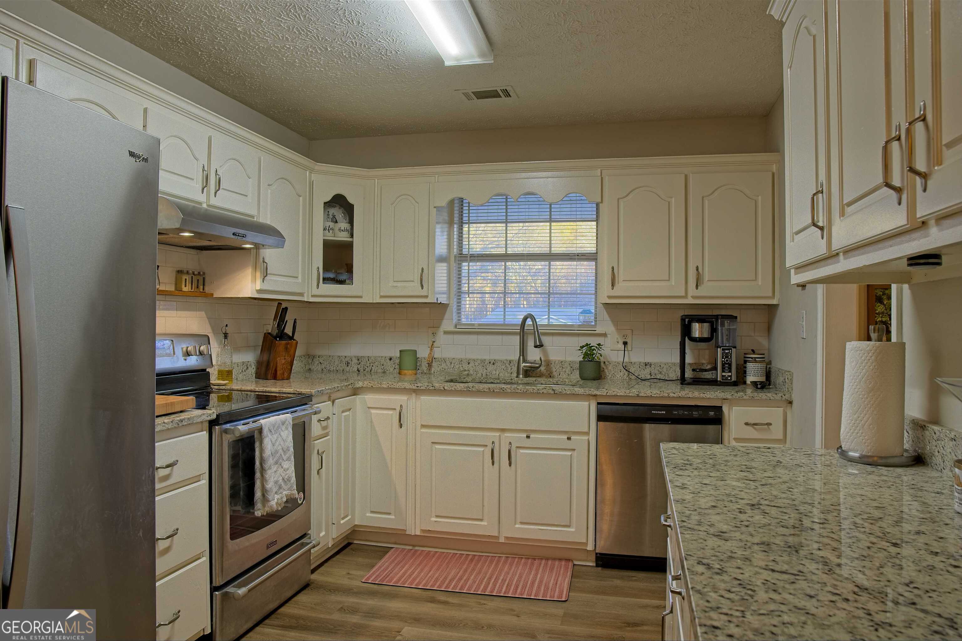 705 Baker Road Oxford, GA 30054 - Photo 17 of 50 a kitchen with stainless steel appliances granite countertop a stove a sink and a refrigerator
