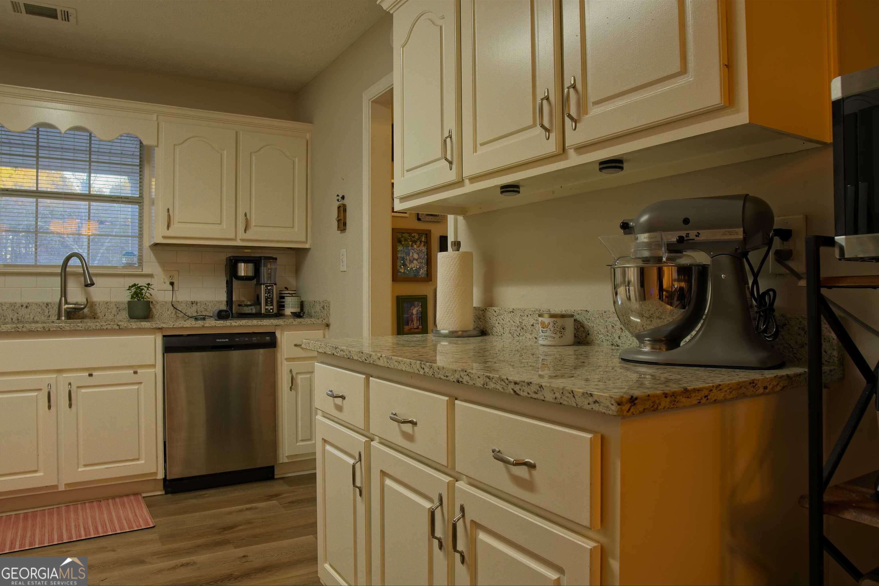 705 Baker Road Oxford, GA 30054 - Photo 18 of 50 a kitchen with granite countertop a sink stainless steel appliances and cabinets