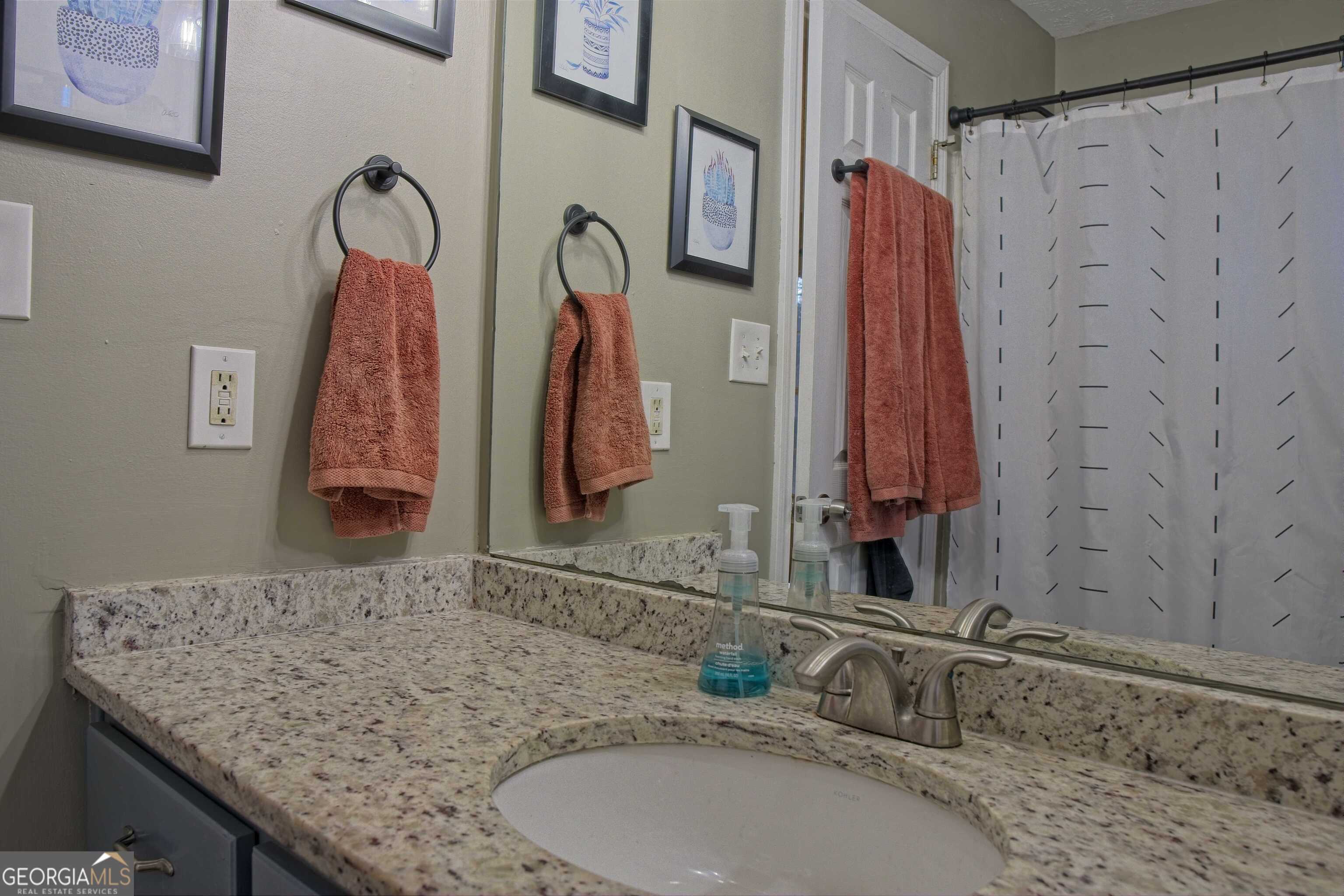 705 Baker Road Oxford, GA 30054 - Photo 30 of 50 a bathroom with a granite countertop sink and a mirror