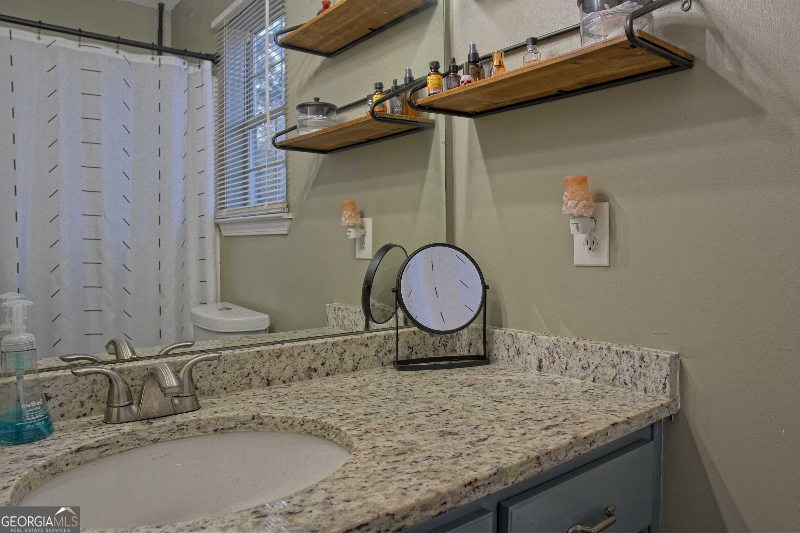 705 Baker Road Oxford, GA 30054 - Photo 31 of 50 a bathroom with a granite countertop sink and a mirror