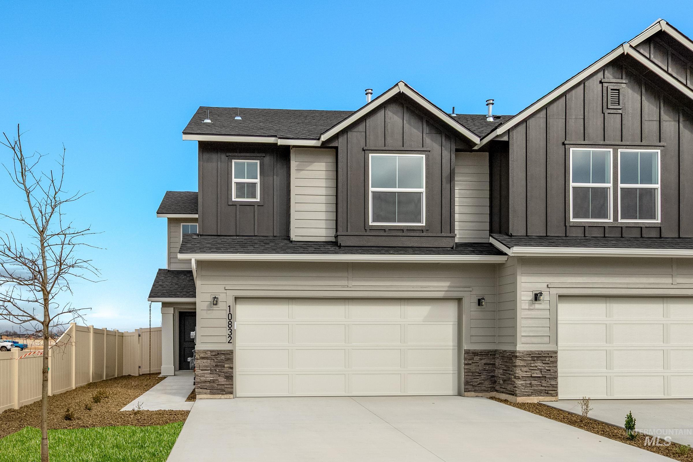 Craftsman-style house featuring stone siding, roof with shingles, board and batten siding, and an attached garage
