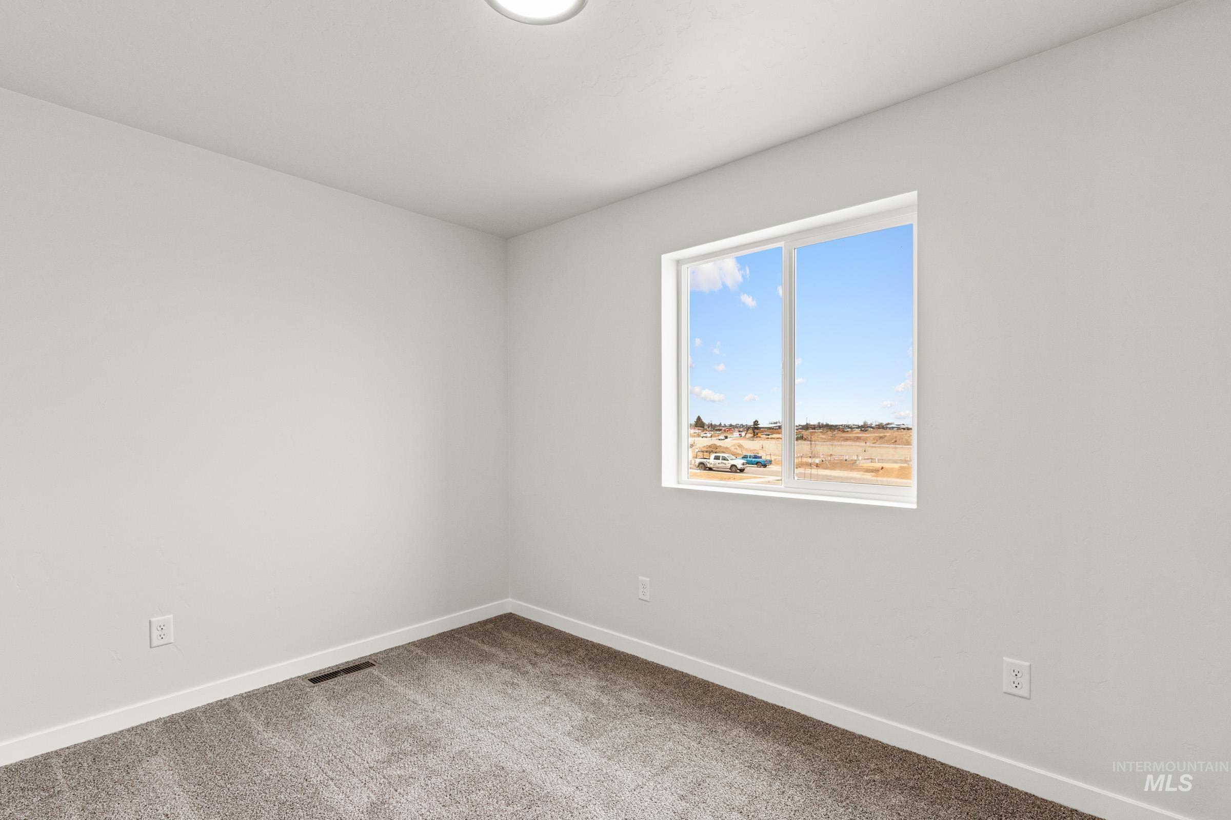 10832 Rutland Street Caldwell, ID 83605 - Photo 10 of 20 Unfurnished room with baseboards and light carpet