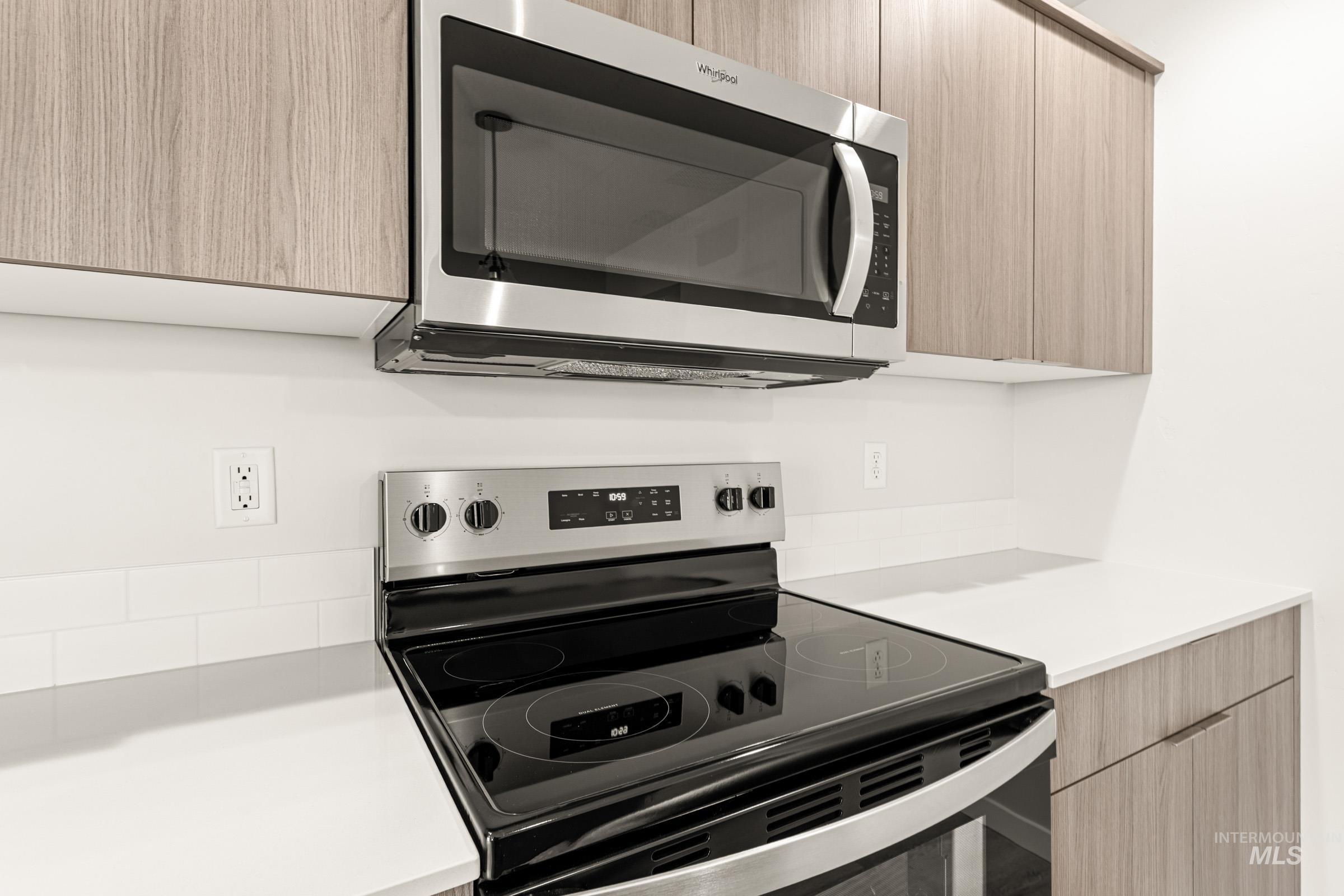 10832 Rutland Street Caldwell, ID 83605 - Photo 5 of 20 Kitchen with stainless steel appliances, modern cabinets, light wood finish cabinetry, and light stone countertops