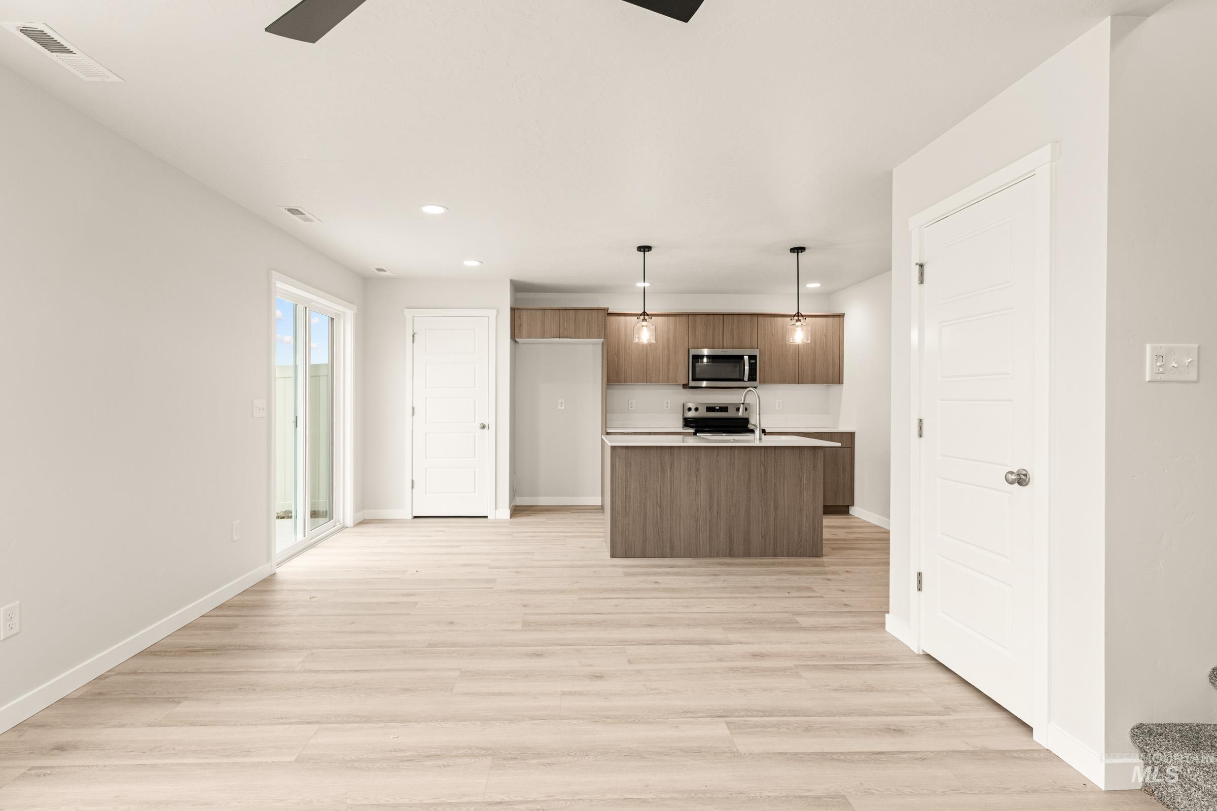 10832 Rutland Street Caldwell, ID 83605 - Photo 9 of 20 Kitchen featuring a ceiling fan, light countertops, a kitchen island with sink, light wood-type flooring, and stainless steel appliances