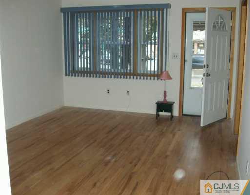 611 Inman Avenue Colonia, NJ 07067 - Photo 2 of 7 a view of an empty room with wooden floor and a window