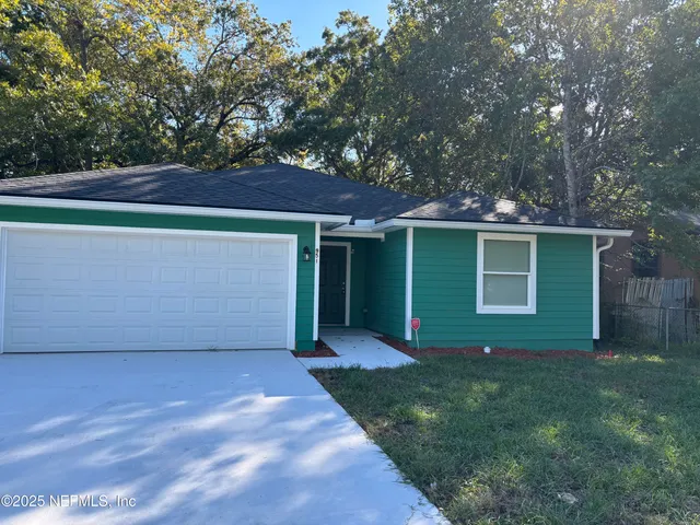 front view of a house with a yard and trees