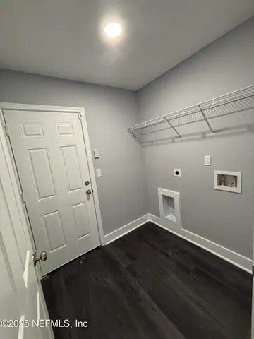 an empty room with wooden floor and cabinet